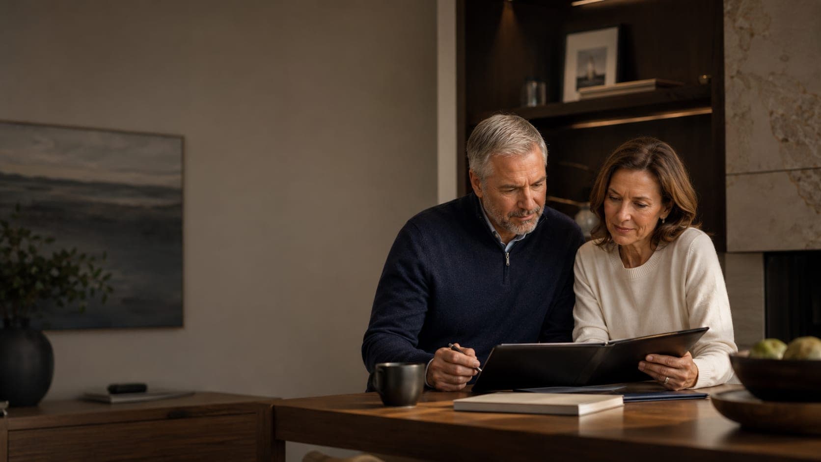 A mature couple reviewing financial documents together at their dining table